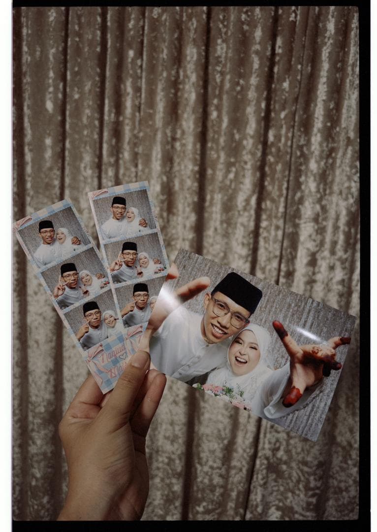 A guest holding freshly printed firphotobooth photostrips